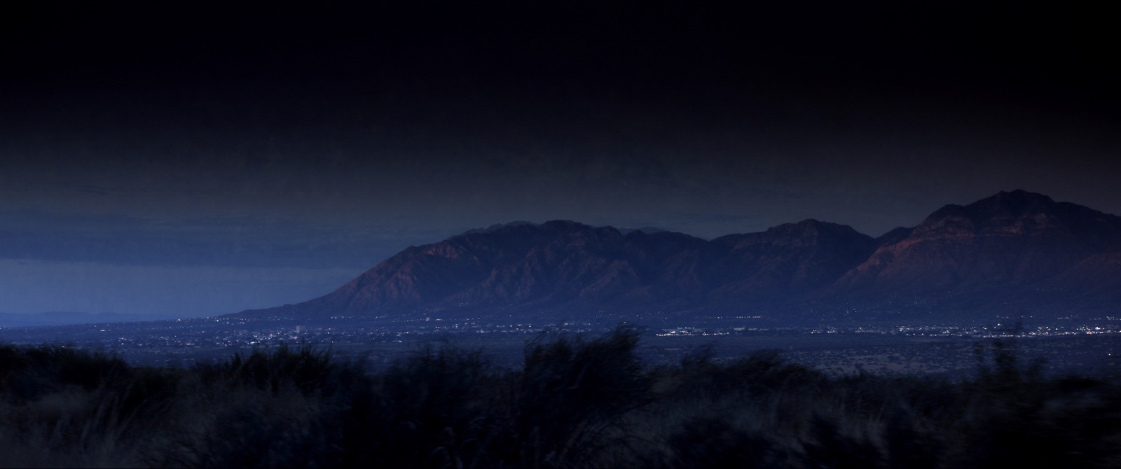 The Sandia Mountains at dusk above the lights of Albuquerque